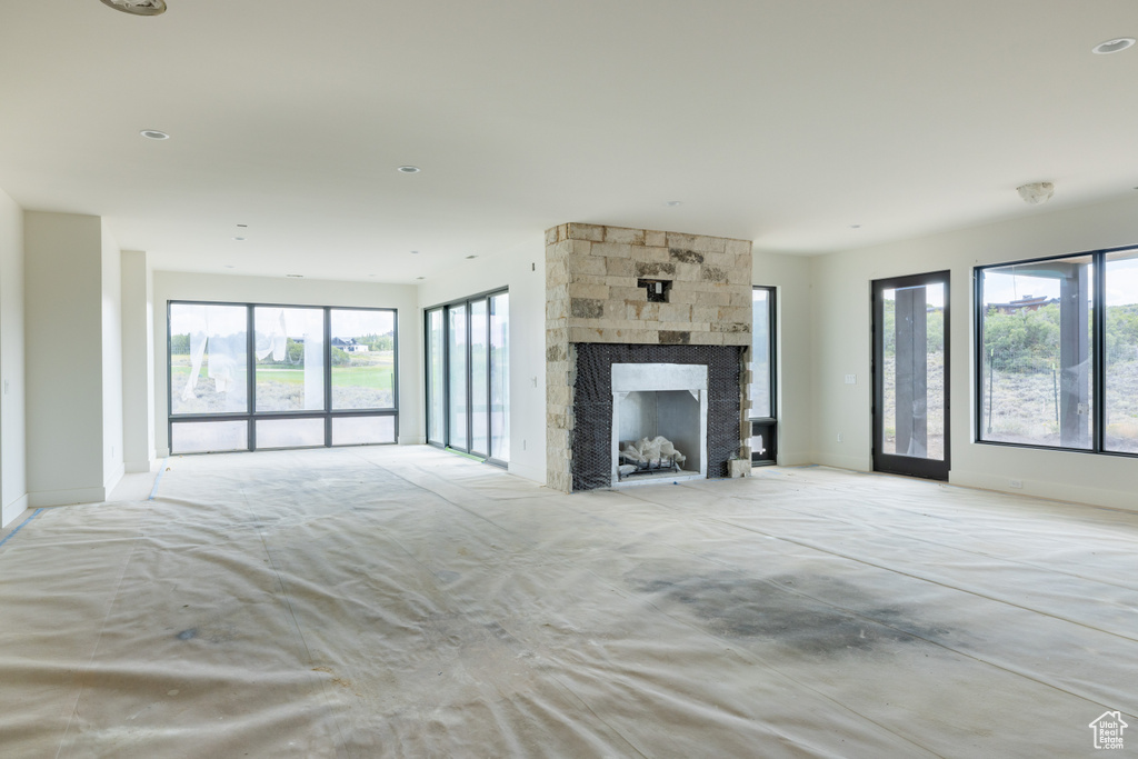 Unfurnished living room with a stone fireplace