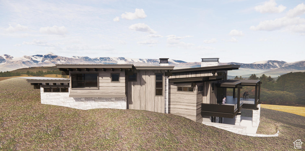 Back of house featuring a mountain view, a yard, and a patio