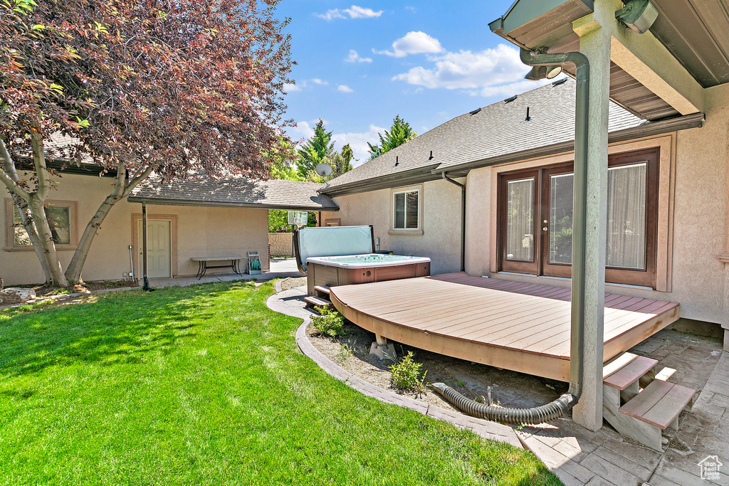 View of yard with a hot tub, french doors, and a deck