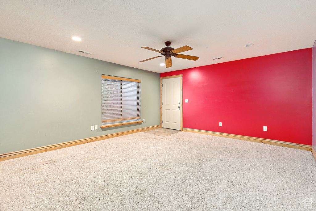 Empty room with ceiling fan and carpet floors