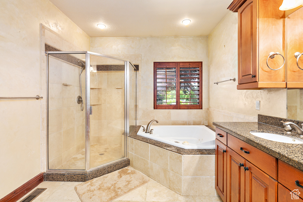 Bathroom featuring tile floors, oversized vanity, and separate shower and tub