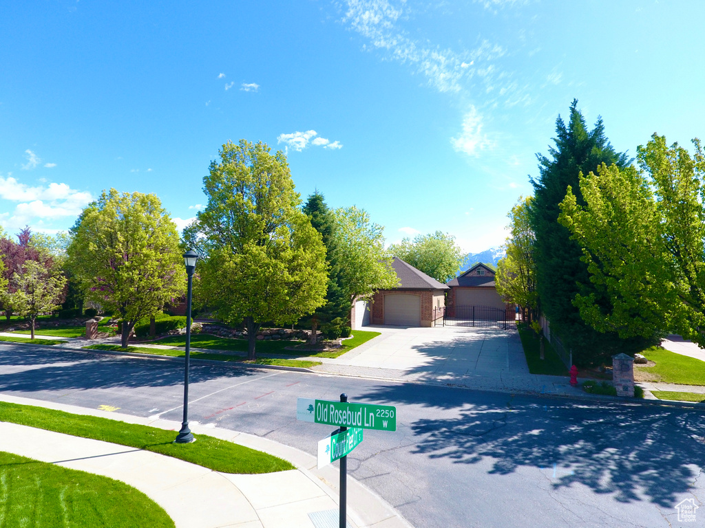 View of property hidden behind natural elements featuring a garage