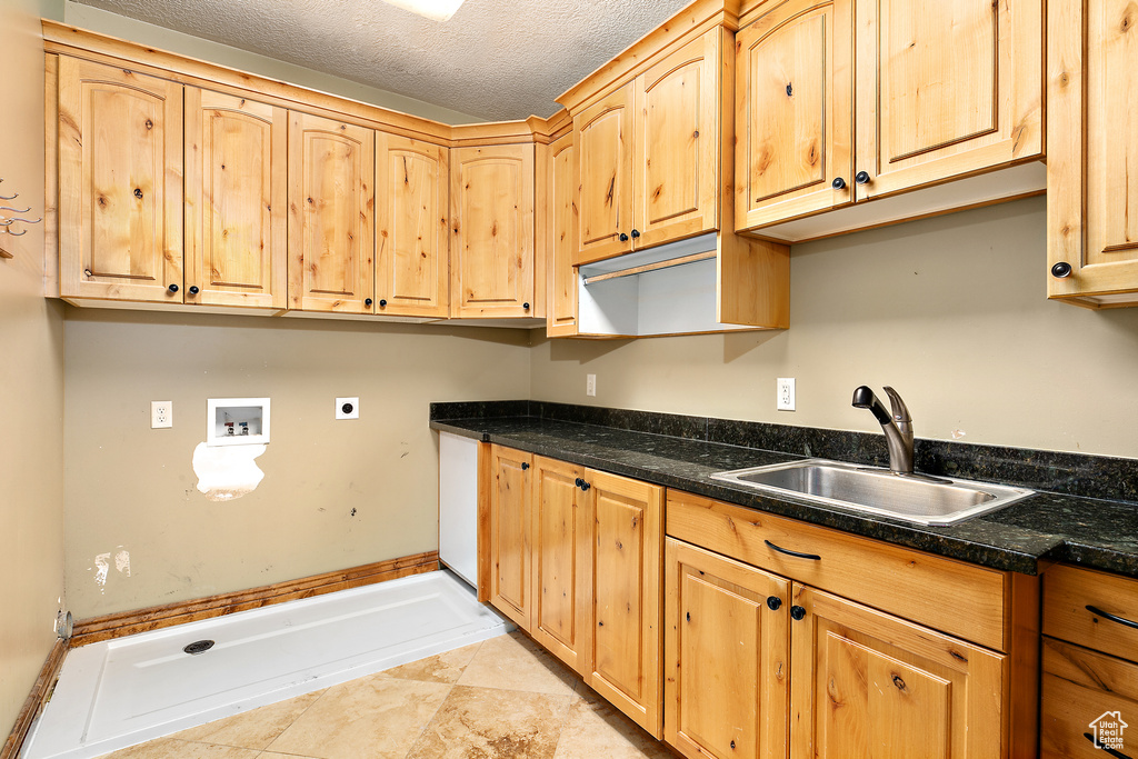 Kitchen featuring sink, a textured ceiling, and light tile flooring