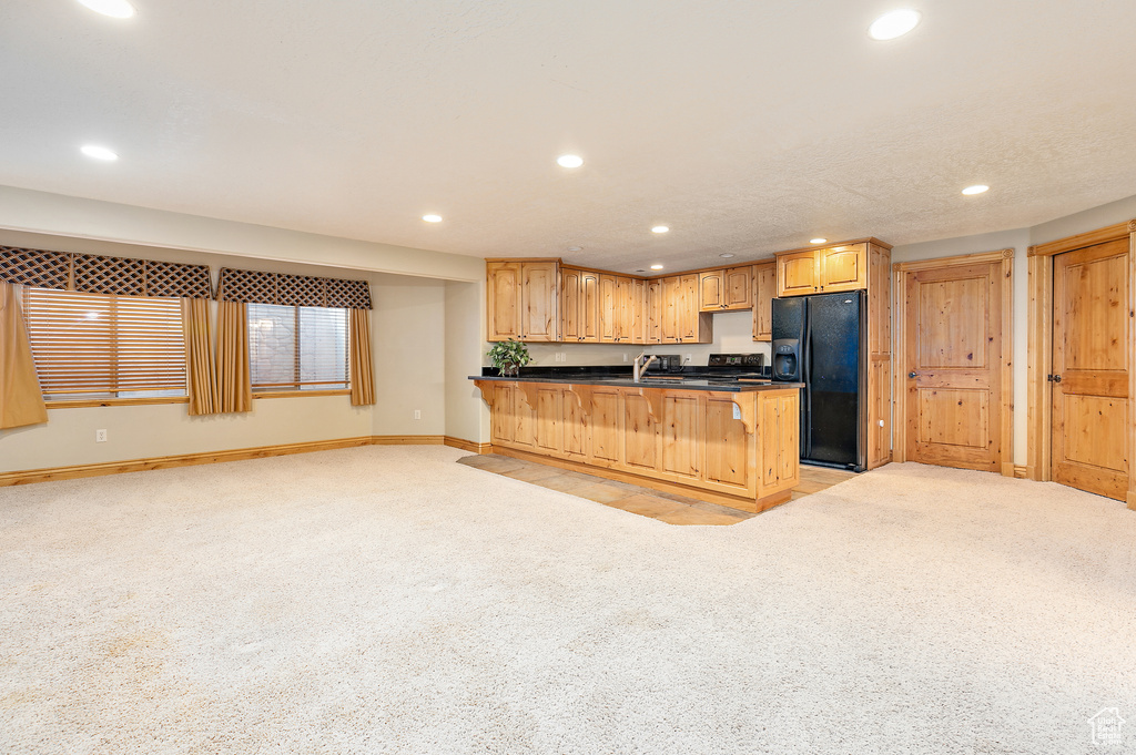 Kitchen featuring sink, light carpet, and black appliances