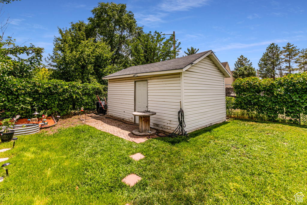 View of outdoor structure featuring a lawn