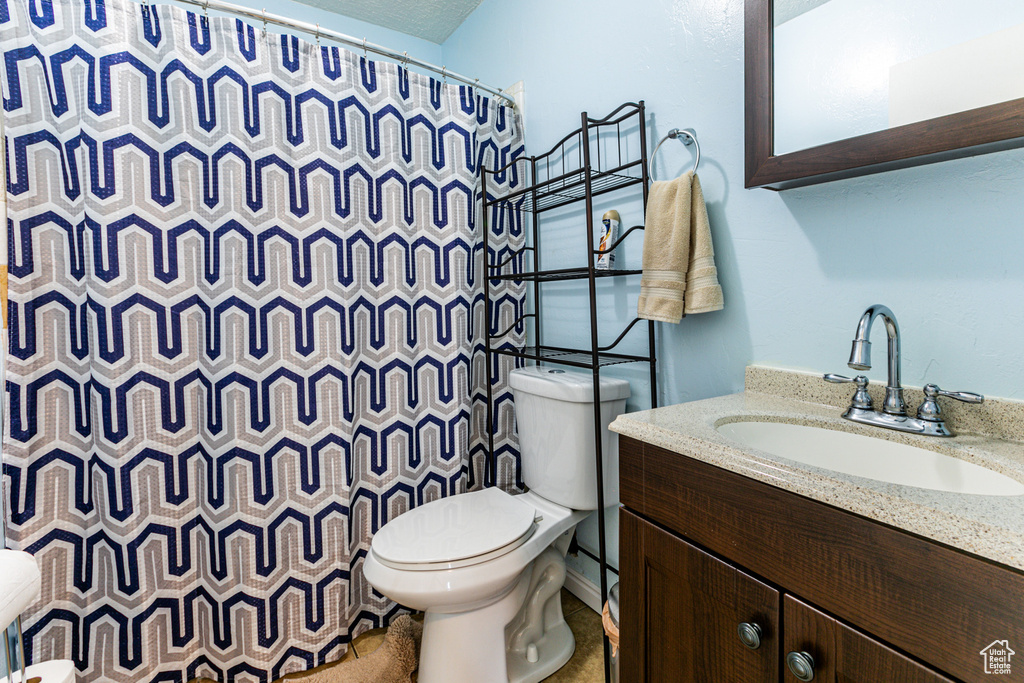 Bathroom featuring toilet and vanity with extensive cabinet space