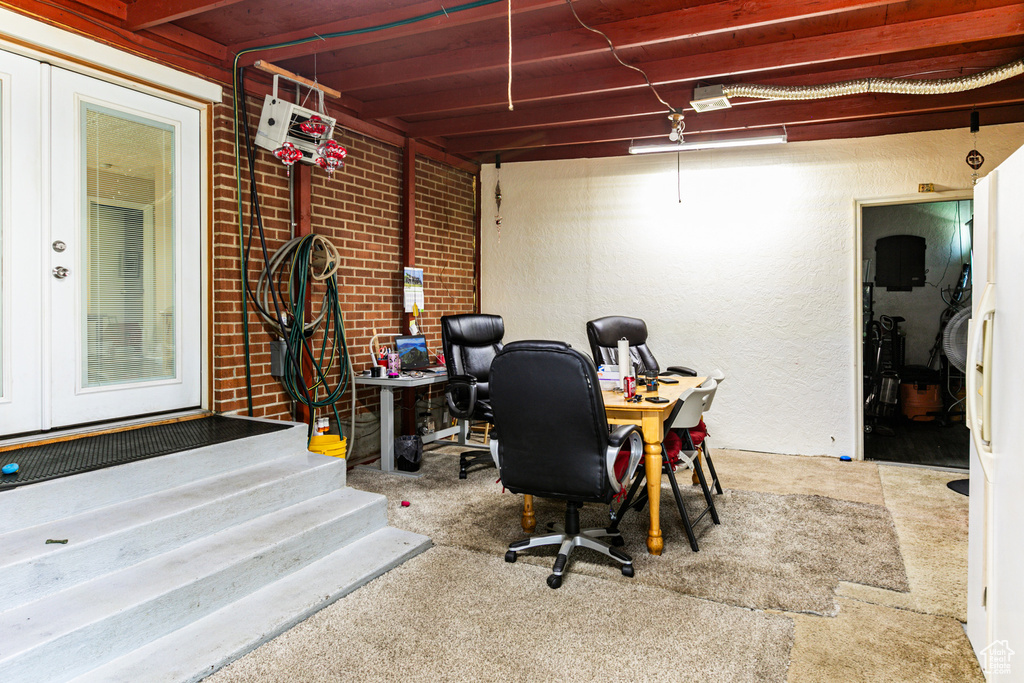 Carpeted home office with brick wall