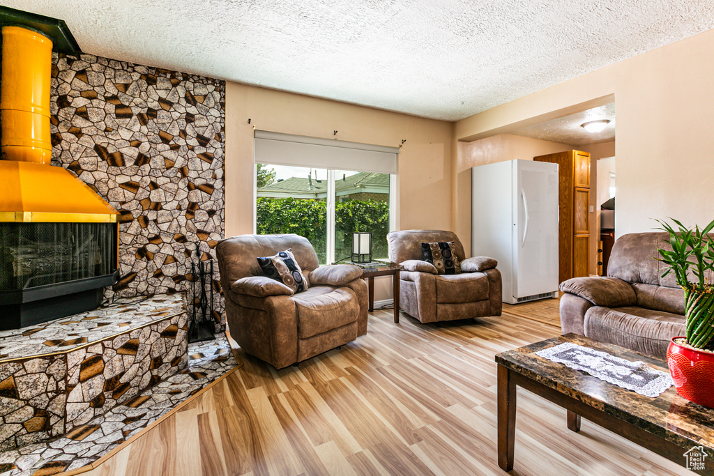 Living room with light hardwood / wood-style flooring and a textured ceiling