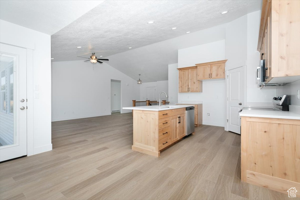 Kitchen featuring light hardwood / wood-style floors, vaulted ceiling, and light brown cabinetry