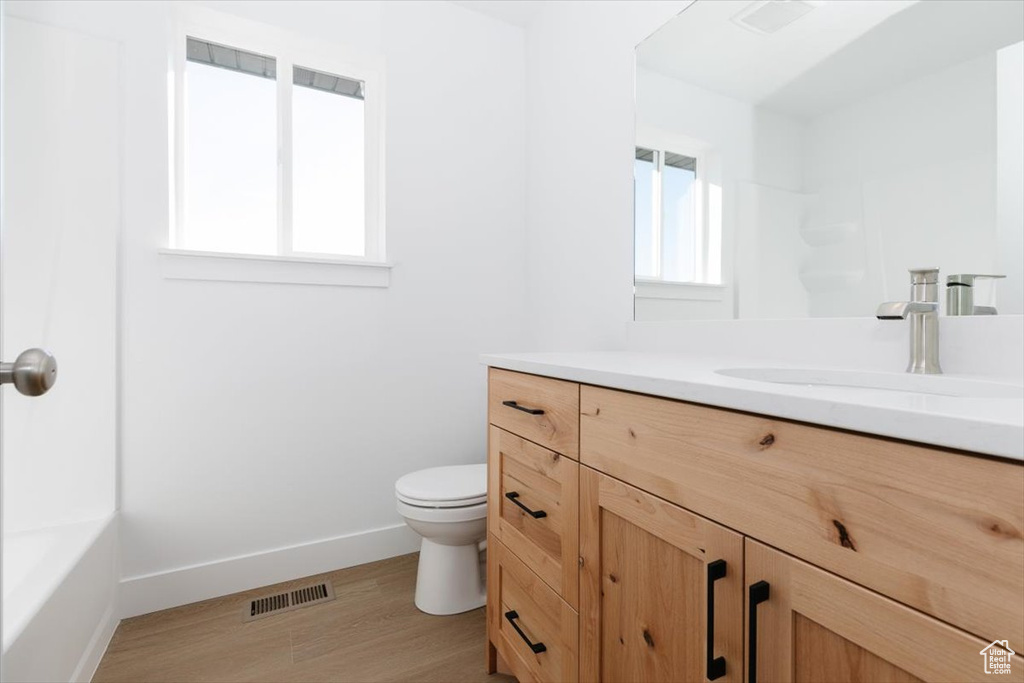 Bathroom featuring vanity, toilet, and hardwood / wood-style flooring