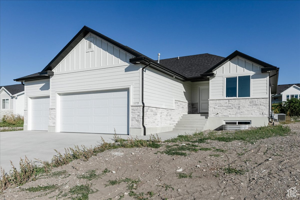 View of front of property with cooling unit and a garage