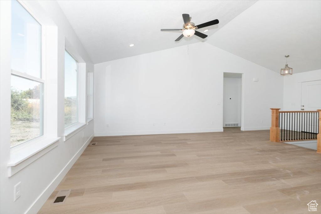 Empty room with vaulted ceiling, ceiling fan, and light hardwood / wood-style flooring