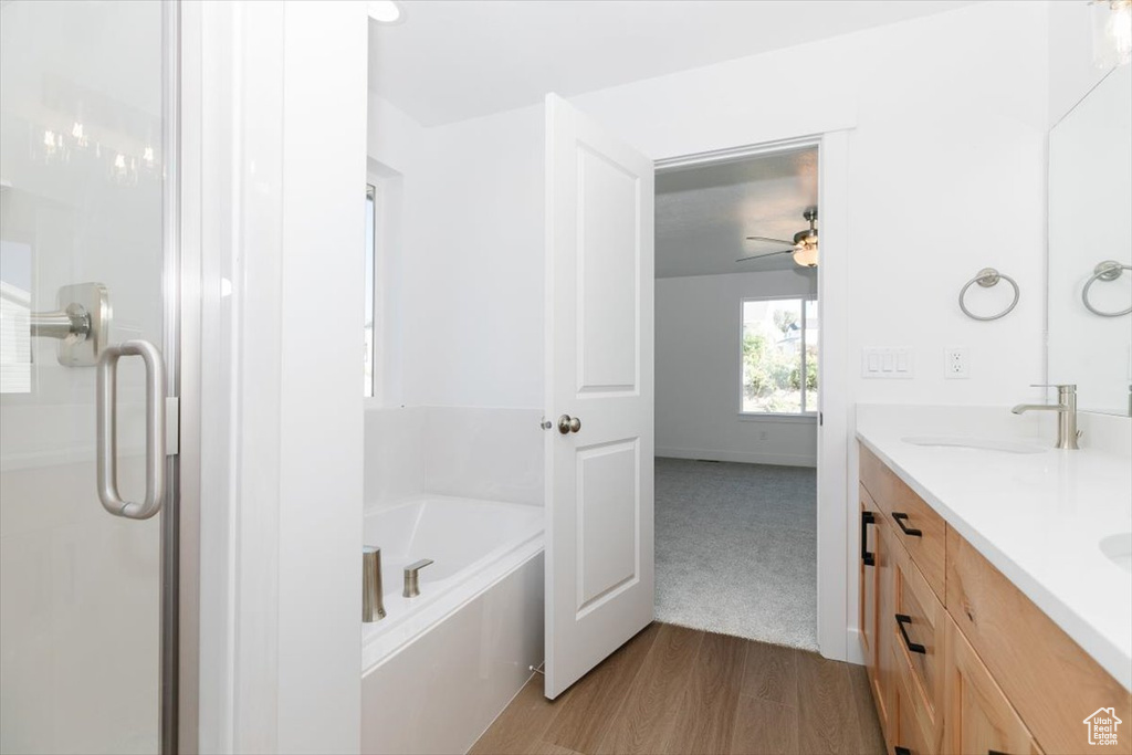 Bathroom with shower with separate bathtub, ceiling fan, hardwood / wood-style flooring, and vanity