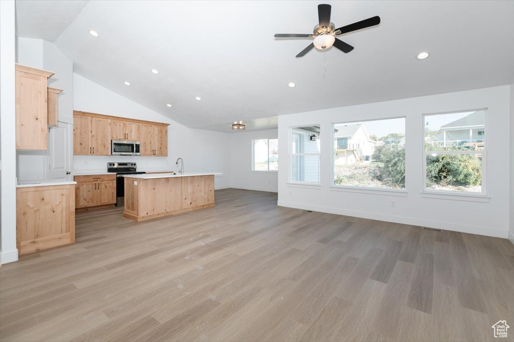 Kitchen with appliances with stainless steel finishes, light wood-type flooring, and a wealth of natural light