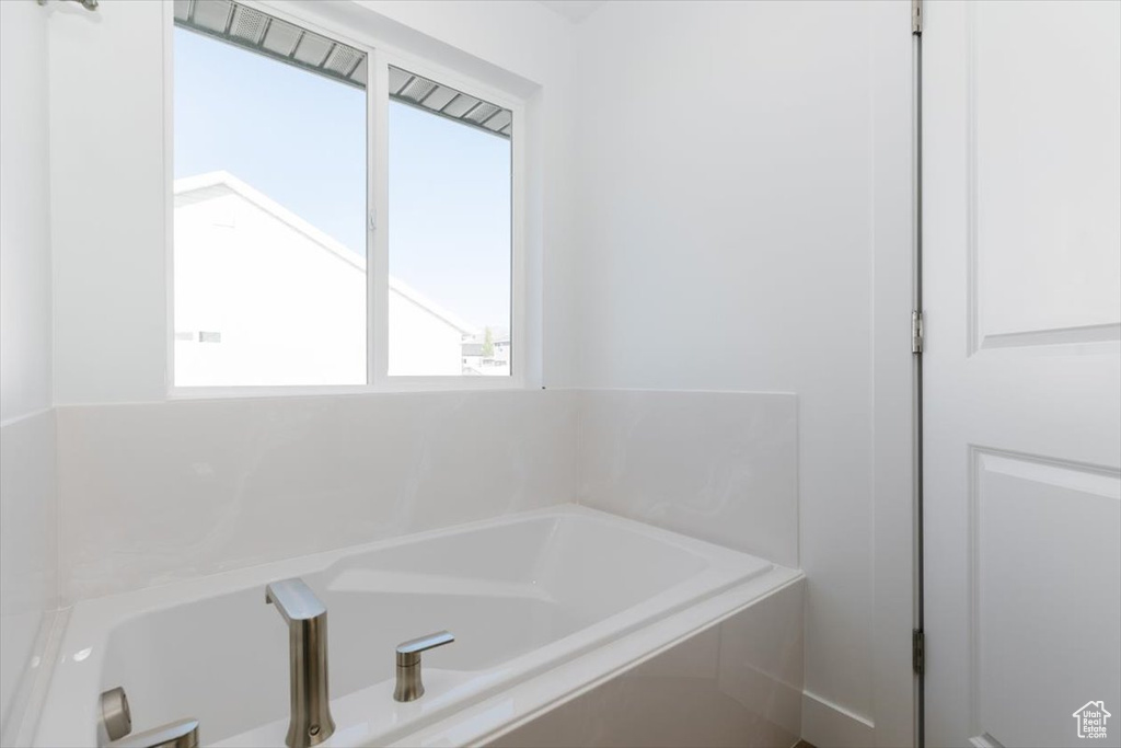 Bathroom featuring plenty of natural light and a tub