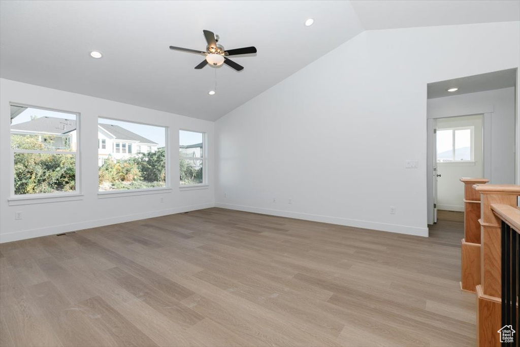 Unfurnished living room featuring lofted ceiling, light hardwood / wood-style floors, and ceiling fan