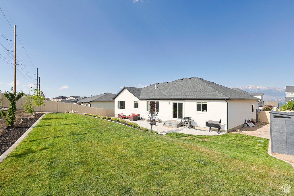 Back of house with a lawn and a patio area