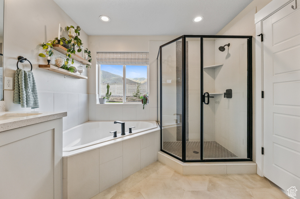 Bathroom with shower with separate bathtub, tile flooring, and vanity