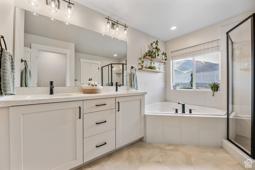 Bathroom with tile flooring, dual vanity, and plus walk in shower