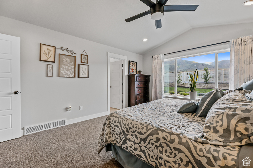 Bedroom featuring ceiling fan, vaulted ceiling, and carpet flooring