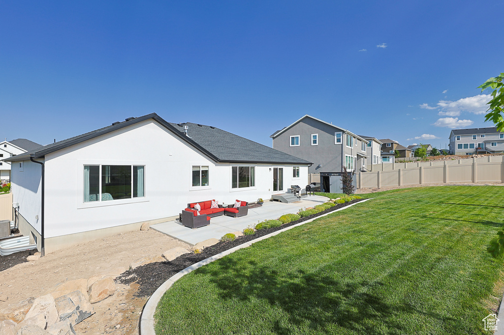 Rear view of property with a yard, a patio area, and an outdoor hangout area