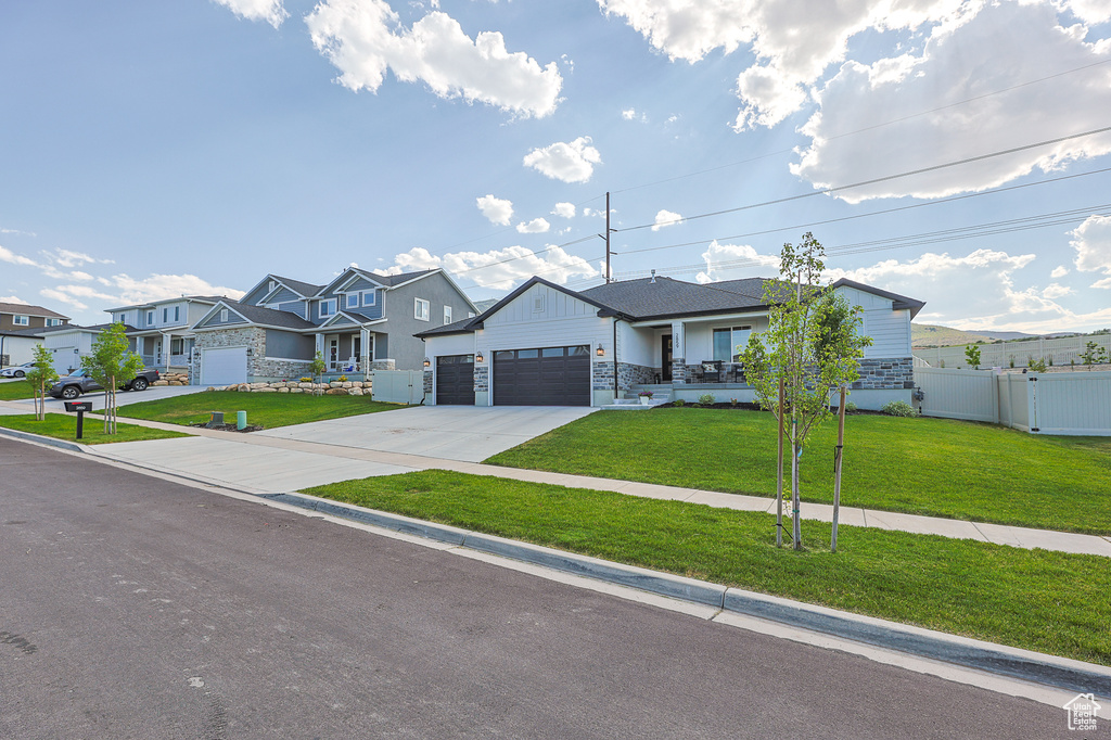 View of front of home with a garage and a front lawn