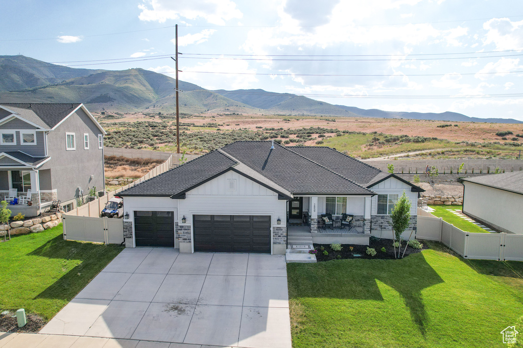 Ranch-style home with a garage, a front yard, and a mountain view