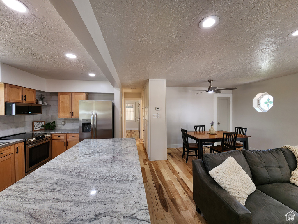 Kitchen with a textured ceiling and stainless steel appliances