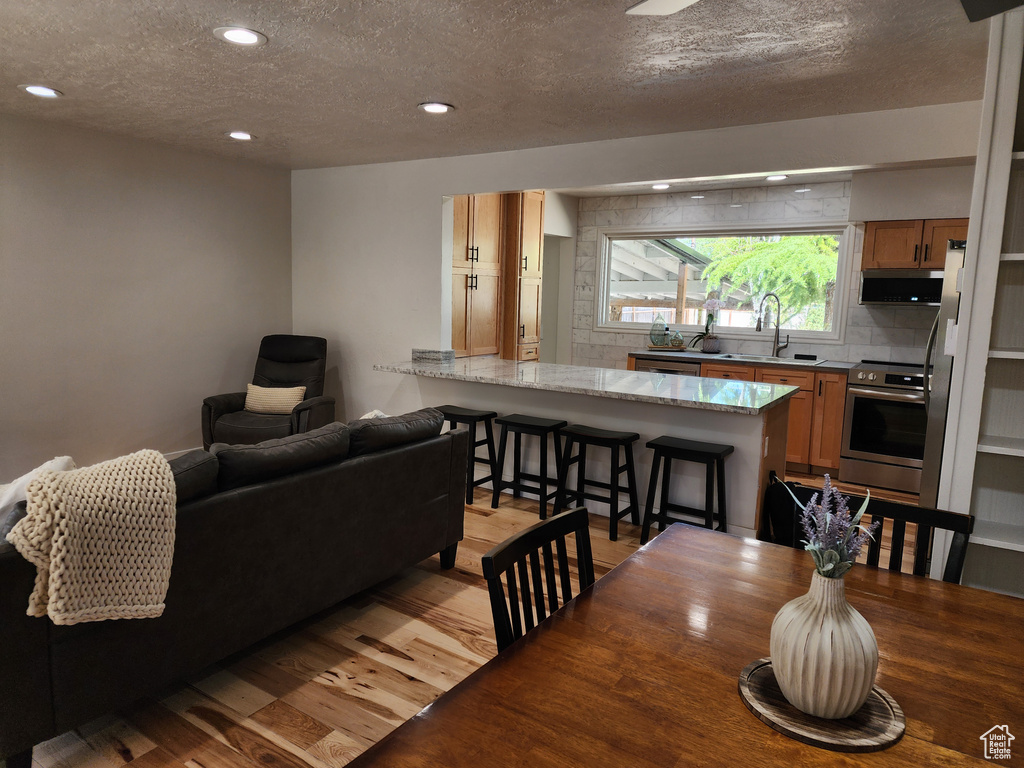 Dining room with hardwood / wood-style floors, sink, and a textured ceiling