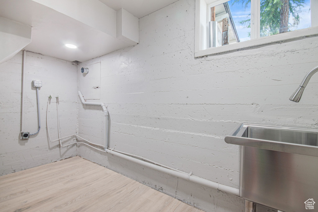 Basement with hardwood / wood-style floors and sink