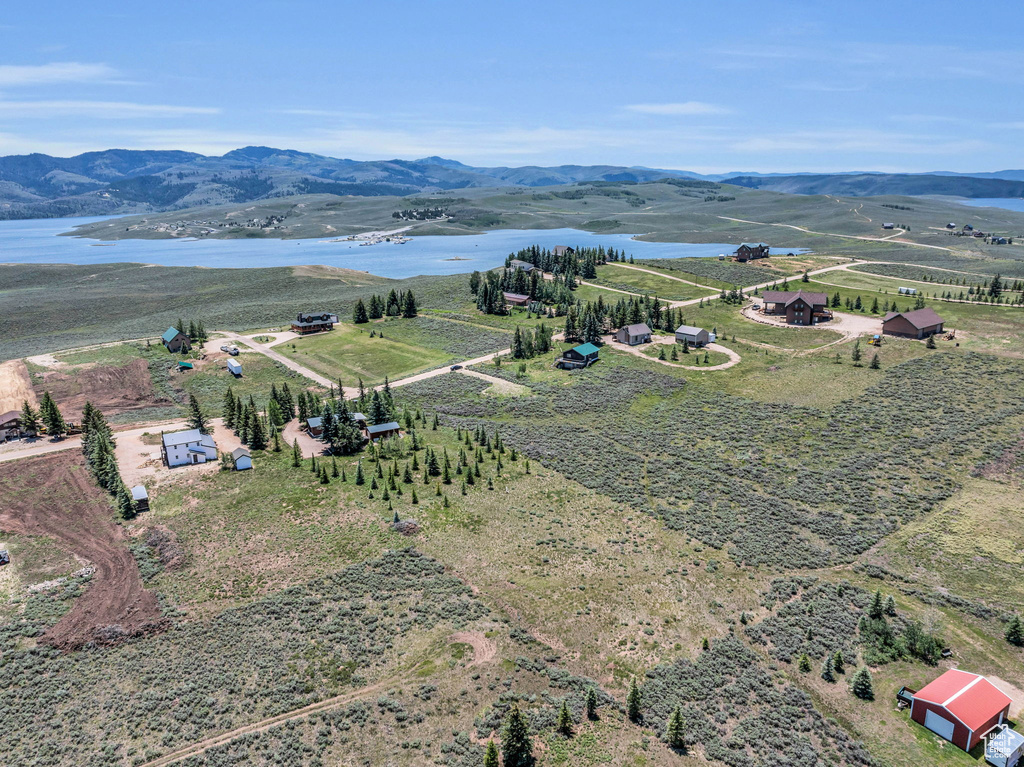 Birds eye view of property featuring a water and mountain view and a rural view