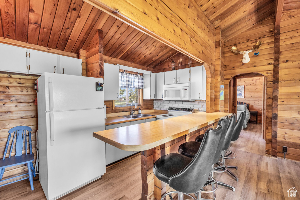 Kitchen featuring light hardwood / wood-style flooring, white cabinetry, wood ceiling, sink, and white appliances