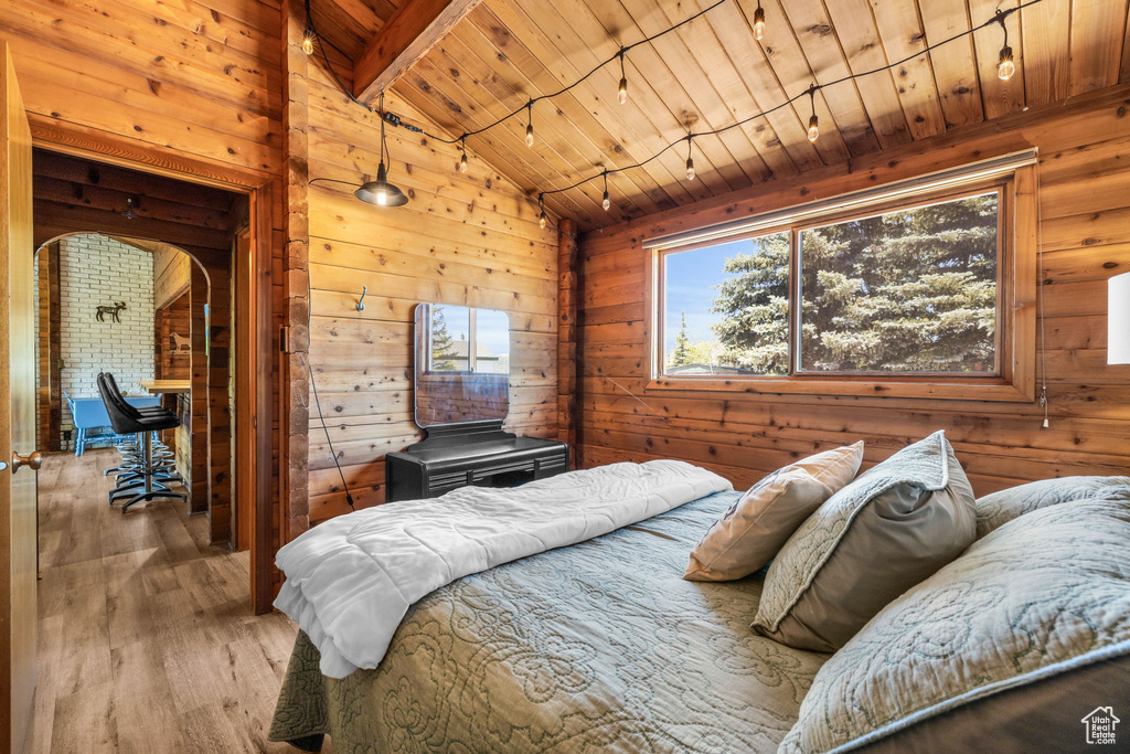 Bedroom with wooden walls, hardwood / wood-style flooring, wood ceiling, and lofted ceiling