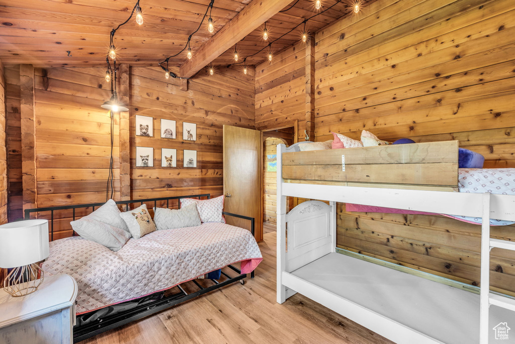 Bedroom featuring wooden ceiling, wooden walls, and hardwood / wood-style floors