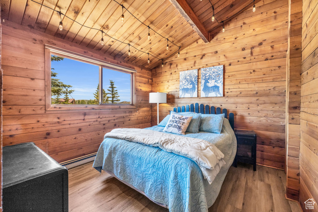 Bedroom with wood-type flooring, lofted ceiling with beams, wooden walls, a baseboard radiator, and wooden ceiling