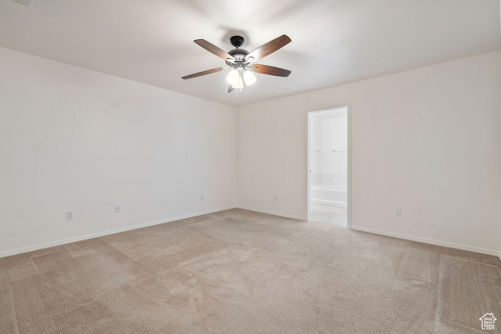 Spare room featuring ceiling fan and light colored carpet