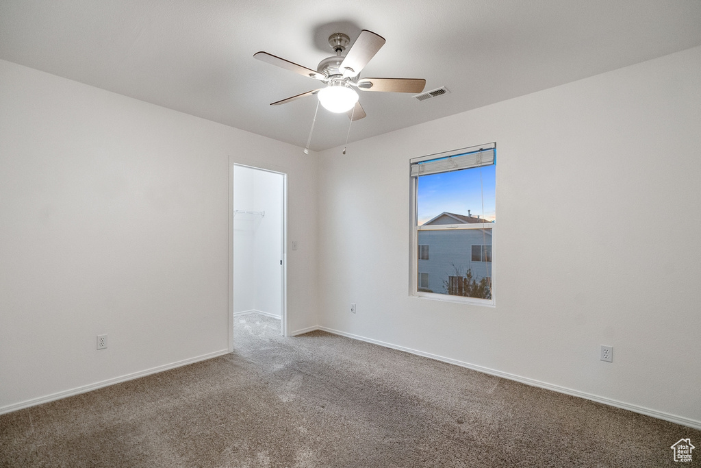 Carpeted spare room featuring ceiling fan