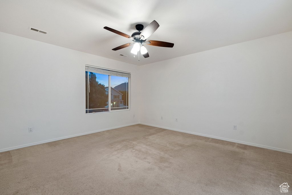 Unfurnished room featuring light colored carpet and ceiling fan