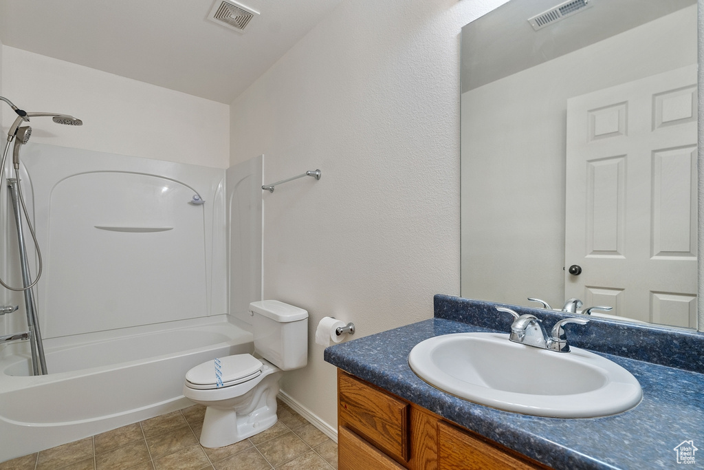 Full bathroom with shower / bath combination, vanity, tile patterned flooring, and toilet