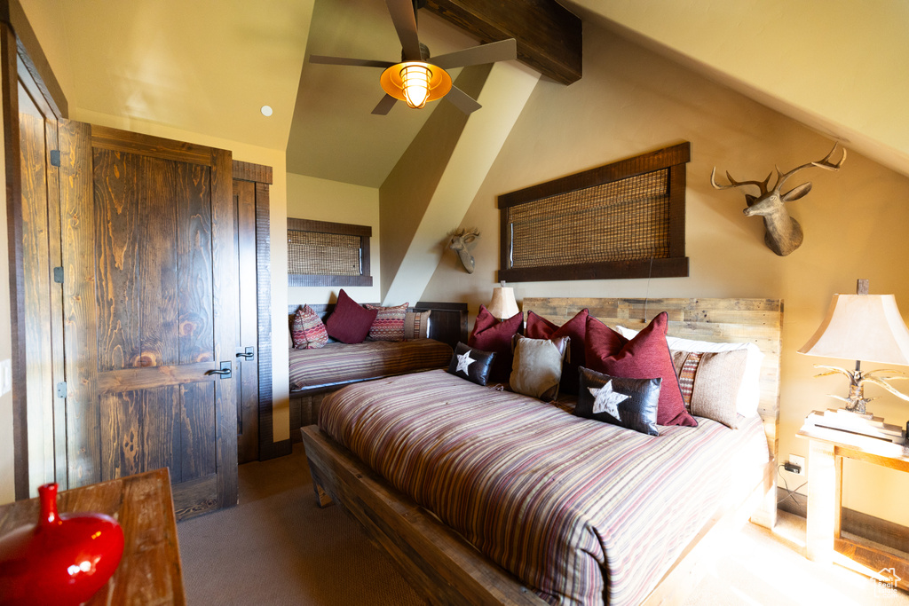 Bedroom featuring carpet floors, vaulted ceiling with beams, and ceiling fan