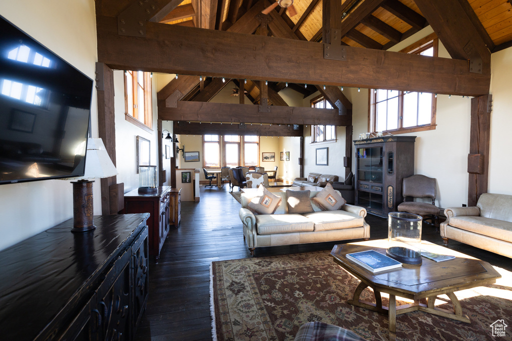 Living room featuring beamed ceiling, high vaulted ceiling, wooden ceiling, and dark wood-type flooring