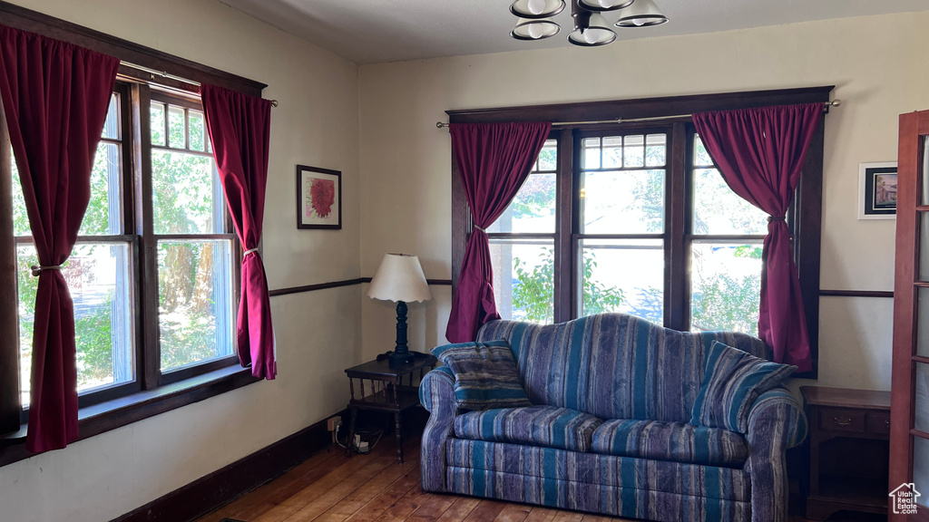 Living room featuring a healthy amount of sunlight, a notable chandelier, and hardwood / wood-style floors