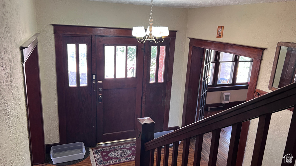 Foyer entrance featuring an inviting chandelier, hardwood / wood-style flooring, and a textured ceiling