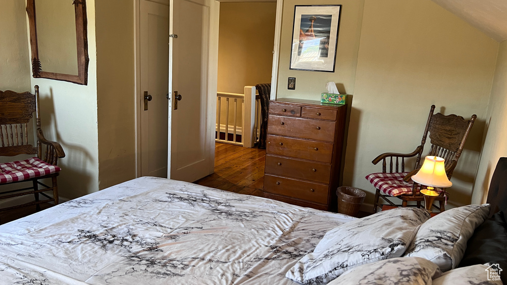 Bedroom featuring a closet, vaulted ceiling, and dark hardwood / wood-style flooring