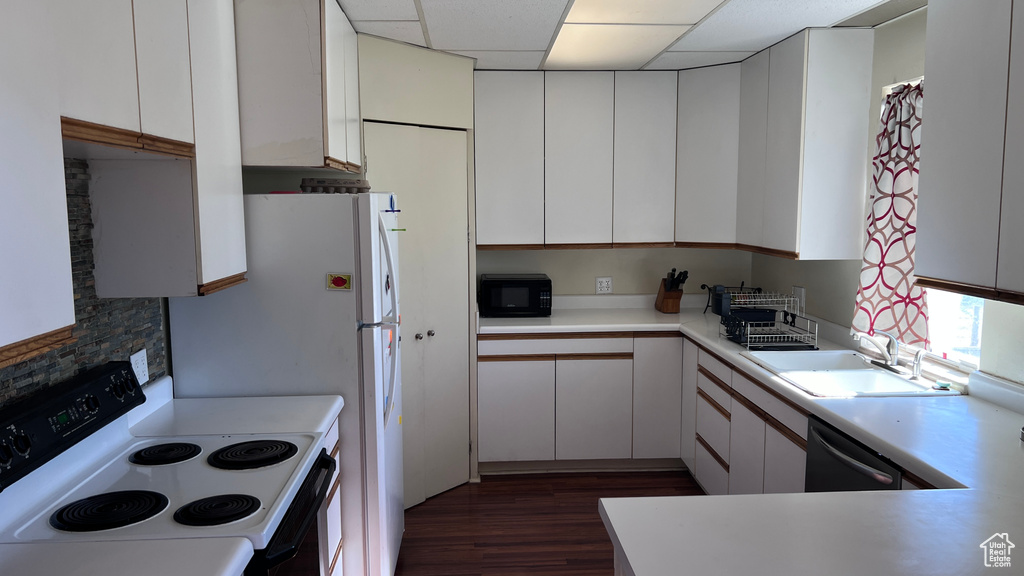 Kitchen featuring white cabinetry, dark wood-type flooring, stove, and a paneled ceiling