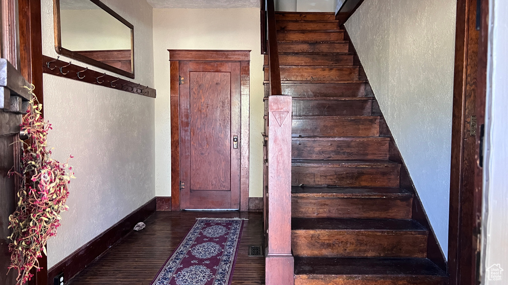 Stairway with dark hardwood / wood-style floors