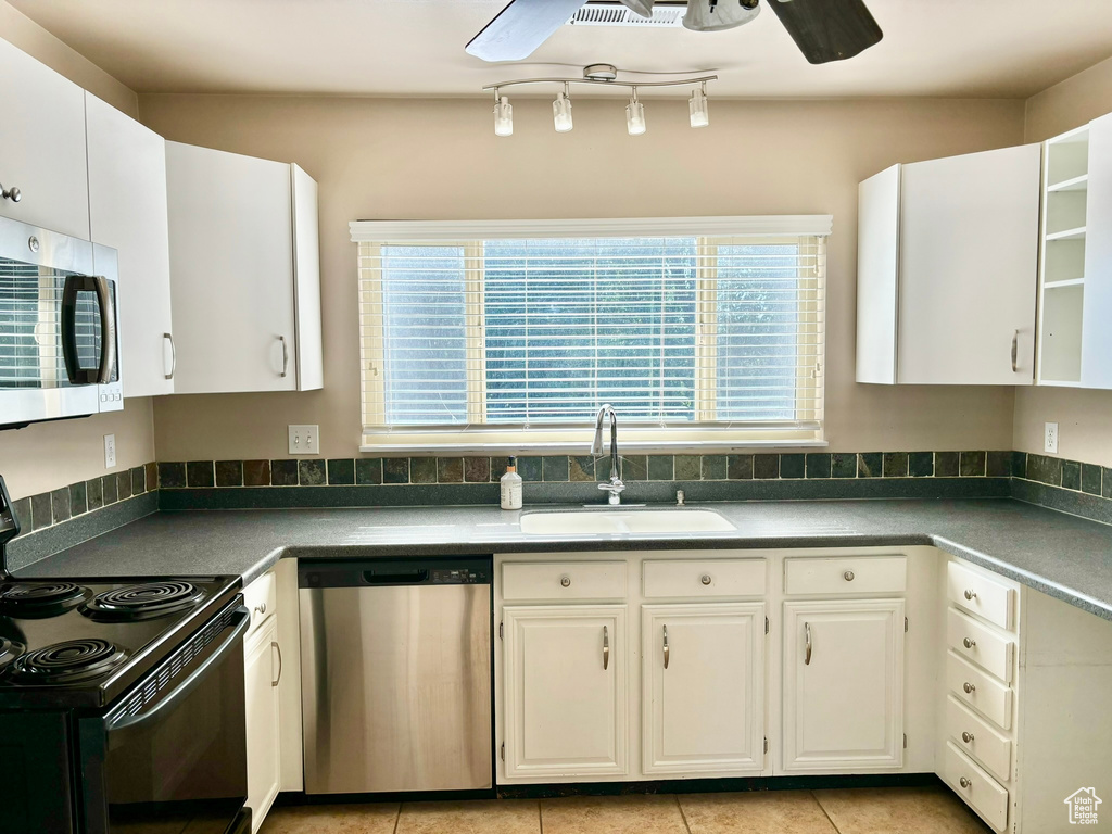 Kitchen featuring ceiling fan, rail lighting, sink, white cabinetry, and appliances with stainless steel finishes