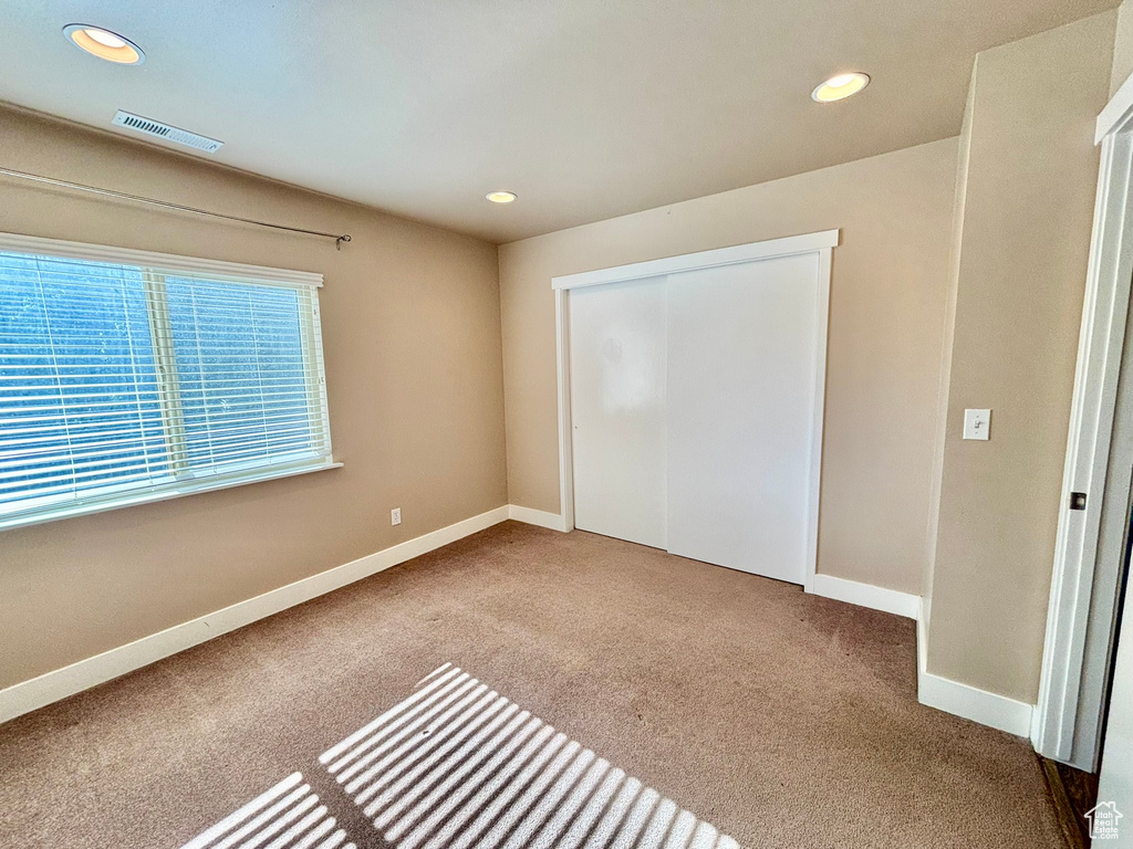 Unfurnished bedroom featuring carpet flooring and a closet