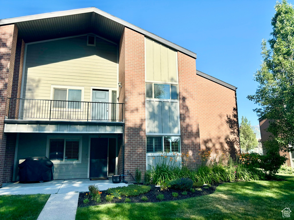 View of front of house featuring a front lawn and a balcony