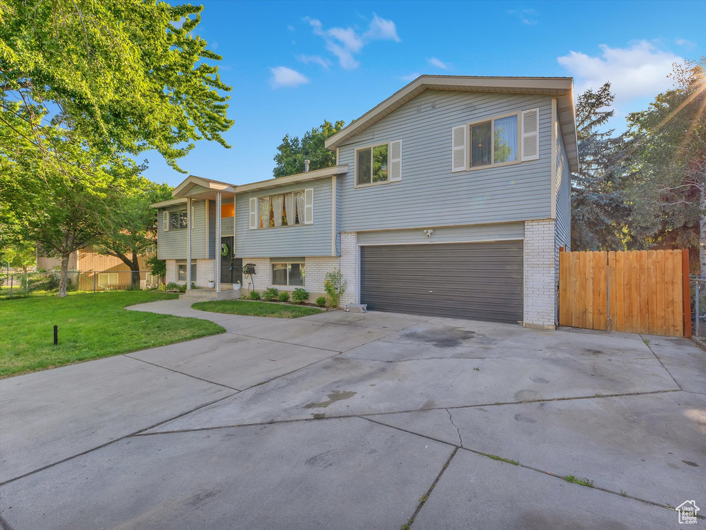 View of front of house with a garage and a front yard